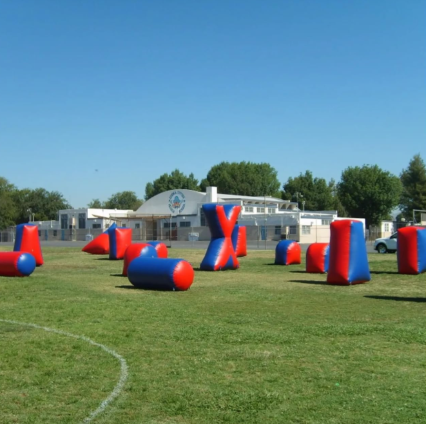 Red and blue inflatable Sportogo field obstacles deployed on a grass field